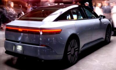 Sleek silver electric car showcased at an auto event.