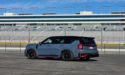 A sporty gray SUV with black and red accents parked on an empty race track.