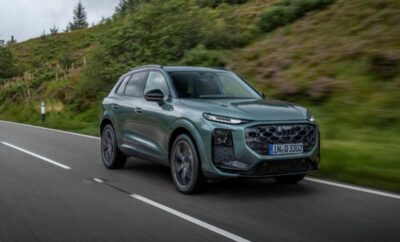A sleek, modern SUV driving on a winding road surrounded by greenery.