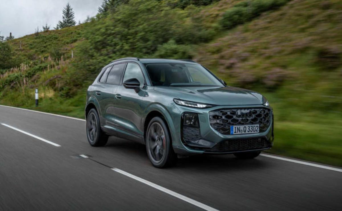A sleek, modern SUV driving on a winding road surrounded by greenery.