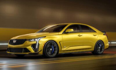 Sleek yellow sports car speeding on a city street at night.