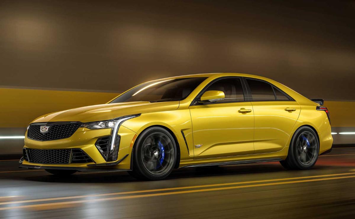 Sleek yellow sports car speeding on a city street at night.