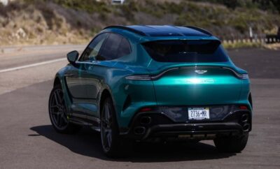 Sleek teal luxury SUV parked outdoors with scenic background.