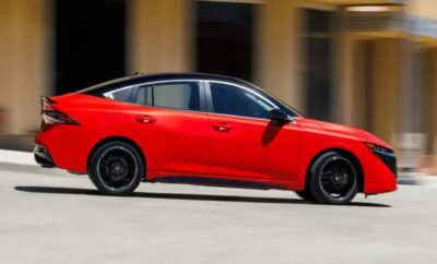 Sleek red sports car with black wheels parked in front of a modern building.