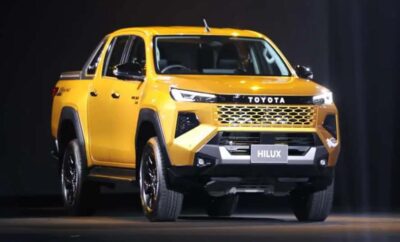 Yellow Toyota Hilux pickup truck showcased indoors.