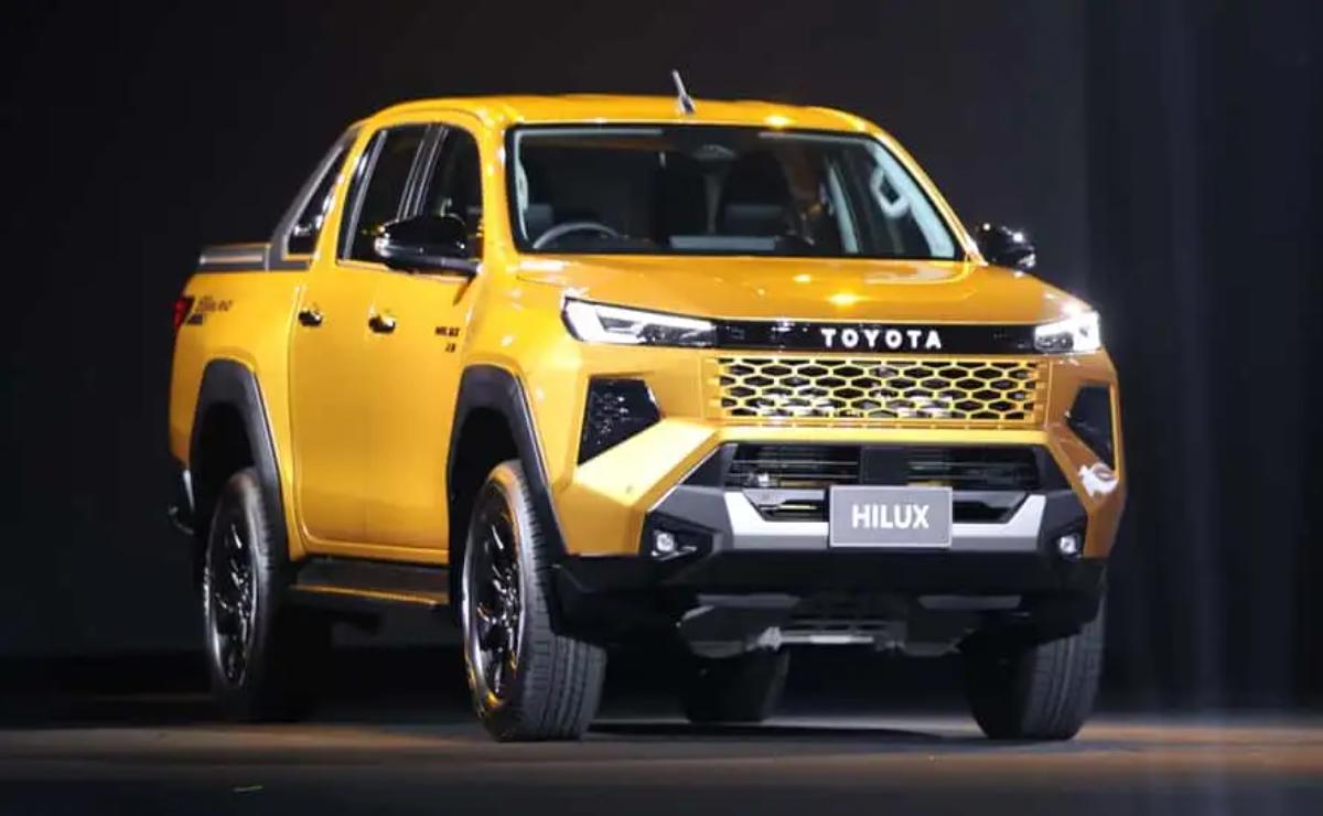Yellow Toyota Hilux pickup truck showcased indoors.