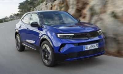 Blue Opel Mokka parked near a rocky cliff.