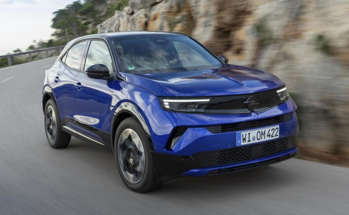 Blue Opel Mokka parked near a rocky cliff.