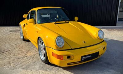 Bright yellow classic Porsche sports car parked outdoors.
