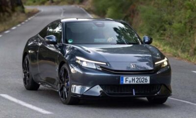 A sleek black Honda car parked on a forest road.