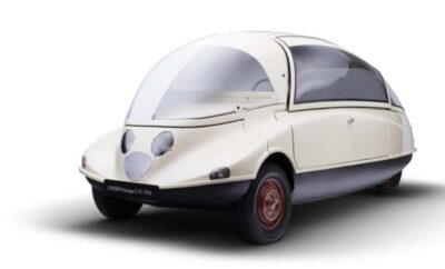 A futuristic vintage white car with a rounded design and large glass canopy.