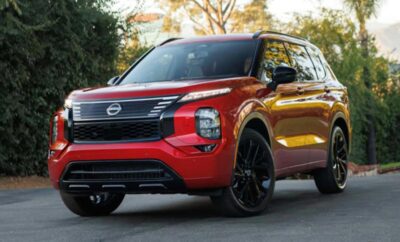 Red Nissan SUV parked outdoors with black accents and wheels.