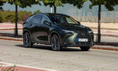 Black Lexus RX SUV parked on a street with trees in the background.