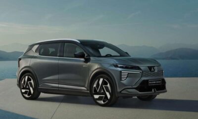 Sleek gray electric SUV parked on a modern concrete platform with mountains in the background.
