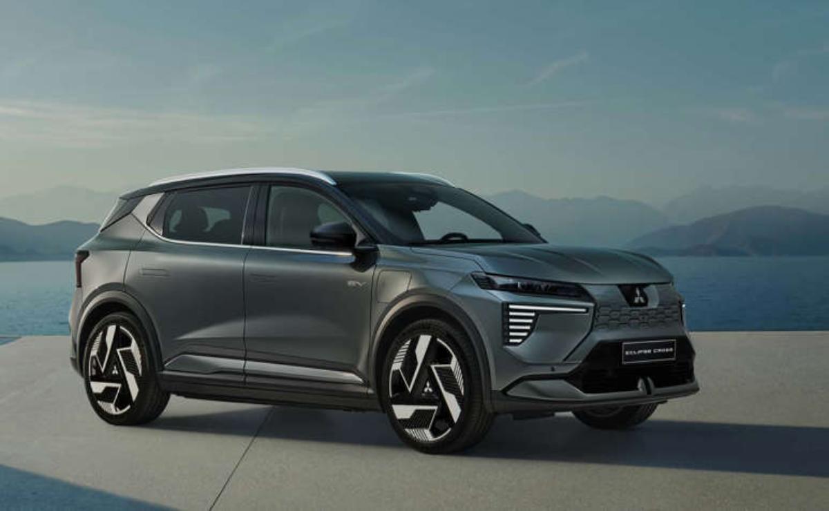 Sleek gray electric SUV parked on a modern concrete platform with mountains in the background.