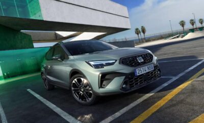 A sleek gray Kia SUV parked outdoors under a clear blue sky.