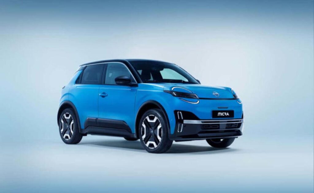 A man working on his laptop and writing in a notebook at a desk.