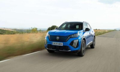 Blue Peugeot SUV driving on a road with scenic background.