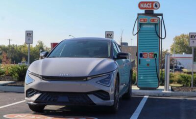 Electric car charging at a fast charger station on a sunny day.