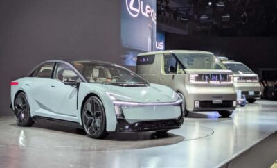 Two modern electric cars displayed at an auto show.