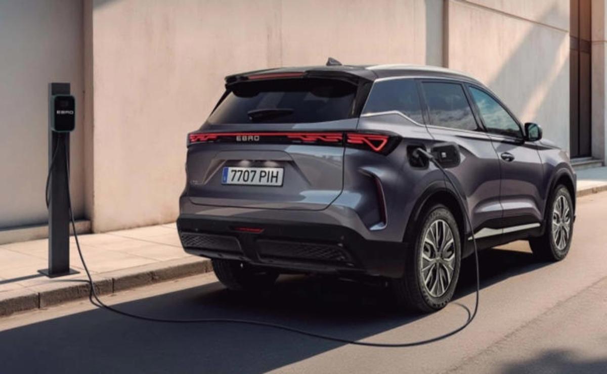 A sleek electric SUV charging at a station on a city street.