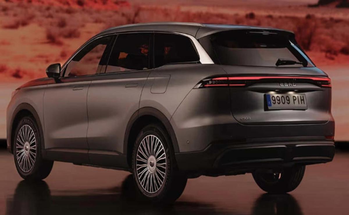 A sleek silver SUV parked on a reddish terrain at dusk.
