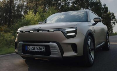 A modern gray electric SUV parked outdoors on a cloudy day.