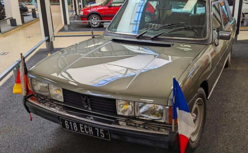A man working on his laptop and writing in a notebook at a desk.