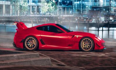 Red sports car parked on a city street at night.