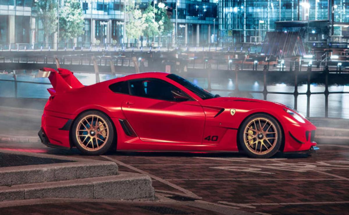 Red sports car parked on a city street at night.