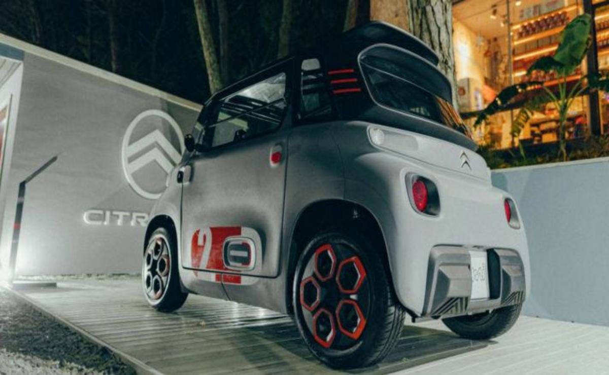 Compact electric car with stylish red accents parked indoors.