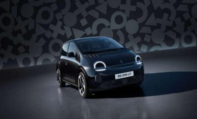 A sleek black electric car with modern LED headlights in a studio setting.