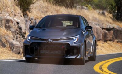 Black sports car speeding on a winding road.