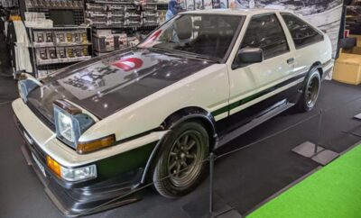 A white and black Toyota AE86 car displayed indoors.