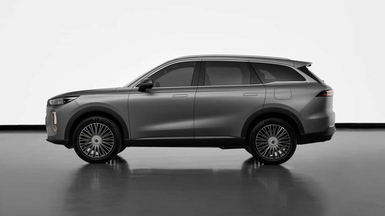 Sleek black luxury SUV with tinted windows on a reflective surface.