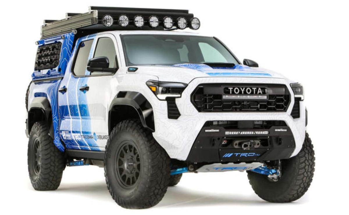 A rugged white Toyota off-road truck with large tires and additional lights.