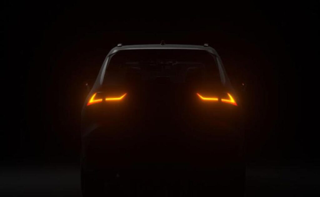 A man working on his laptop and writing in a notebook at a desk.