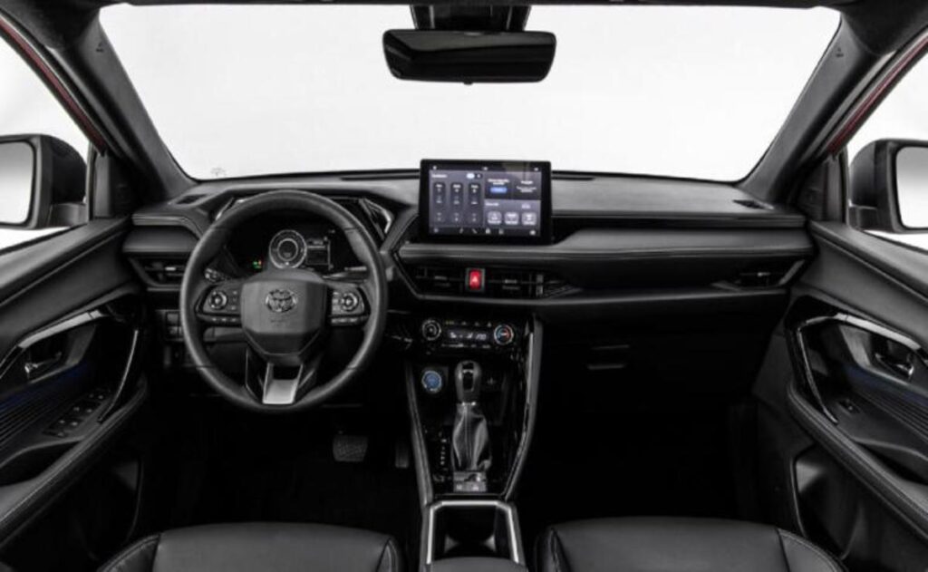 A man working on his laptop and writing in a notebook at a desk.