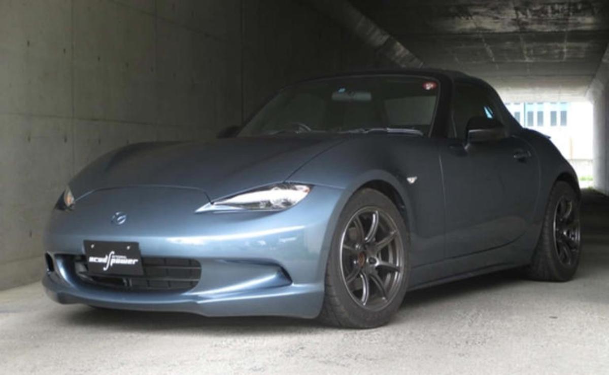 A sleek gray sports car parked in a dimly lit garage.