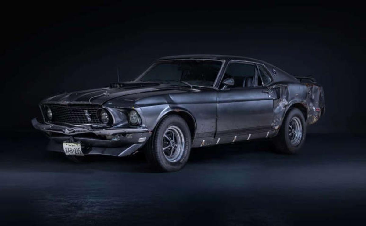 Classic black 1960s muscle car in a dark studio setting.