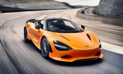 A sleek orange sports car speeding on a race track.