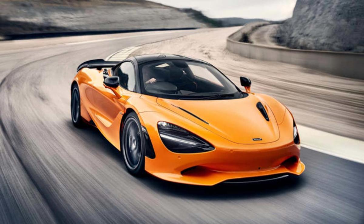 A sleek orange sports car speeding on a race track.