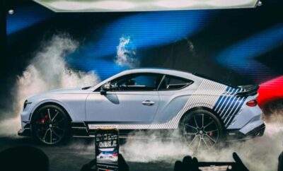 A sleek silver sports car with custom blue and black stripes, surrounded by smoke effects.
