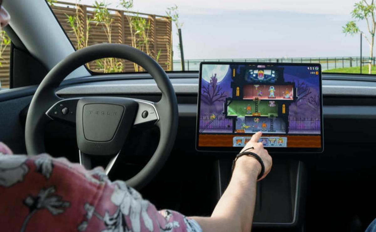 Person using a touchscreen inside a Tesla car.