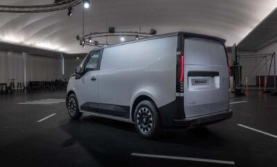Sleek modern electric delivery van parked in a dimly lit urban garage.