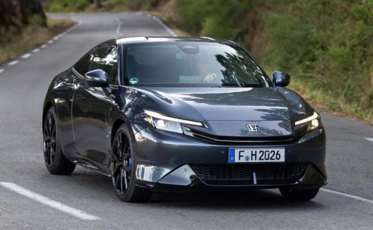 A sleek black electric car driving on a road.