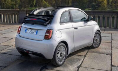 A compact white car with its rear hatch open, parked outdoors.