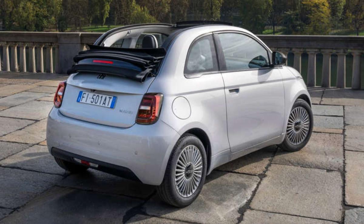 A compact white car with its rear hatch open, parked outdoors.