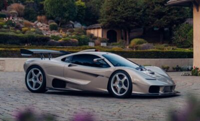 Sleek silver sports car parked on a scenic driveway.
