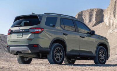 A rugged SUV parked on a rocky terrain with mountains in the background.